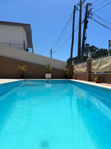 a large blue swimming pool in front of a house at Holiday Villa with Private Pool - Villa Farol in Nazaré