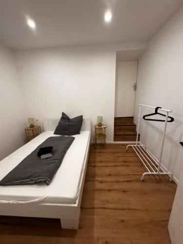 a bedroom with a large white bed and wooden floors at Luxury Apartment nähe Düsseldorf in Wuppertal