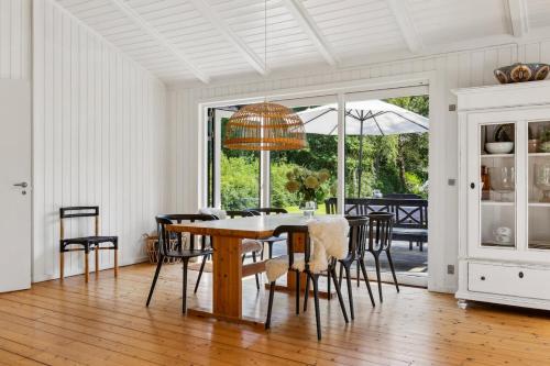 Un comedor con mesa y sillas en Charming Cottage Near Heatherhill With SPA - Rågeleje, en Rågeleje