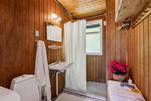 a bathroom with a white shower curtain and a sink at Charming Cottage Retreat Near Heatherhill & Sea Trails - Rågeleje in Vejby