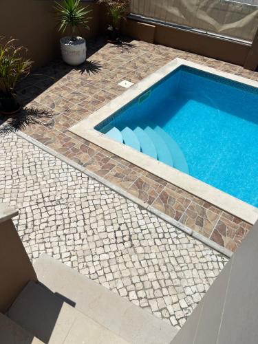 a swimming pool with a stone walkway around it at Holiday Villa with Private Pool - Villa Farol in Nazaré