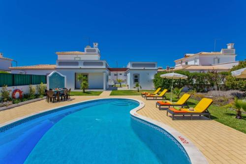 a villa with a swimming pool and patio furniture at Villa Gale Palm by Villa Plus in Albufeira