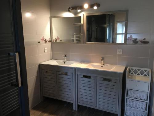 a bathroom with two sinks and a mirror at L'ammonite in Chaunay