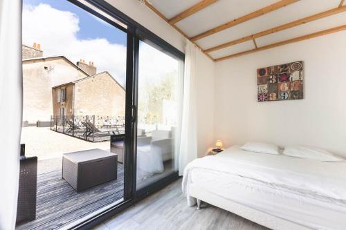 a bedroom with a bed and a large window at Le gite du buis in Montamisé