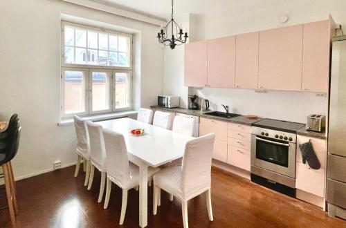 a kitchen with a white table and white chairs at Elegant Jugend city retreat 79m2 in Helsinki