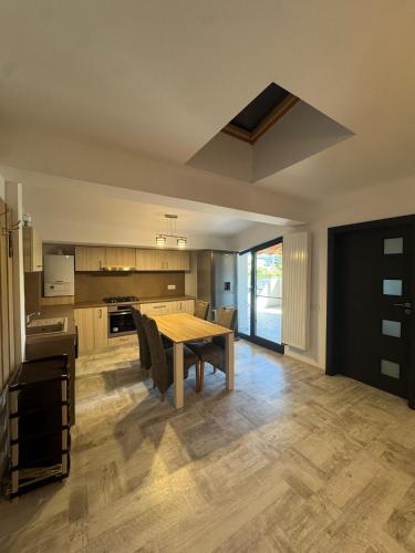 een grote keuken met een houten tafel en stoelen bij Madona Apartment in Craiova