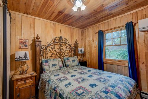 Un dormitorio con una cama en una habitación con paredes de madera. en Bridgepoint Cabin, en Banner Elk