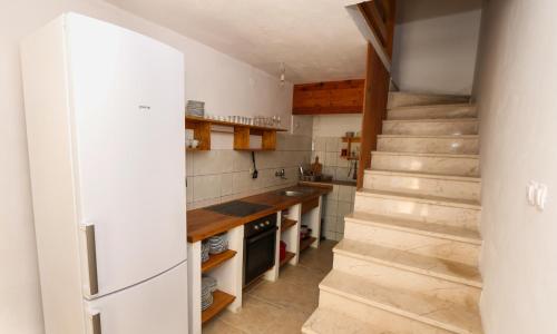 a kitchen with a staircase and a white refrigerator at Kuća na plaži in Razvala