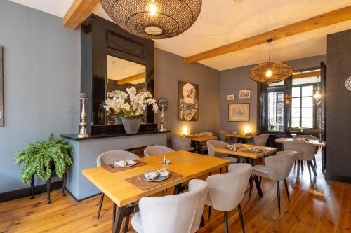 Un restaurante con mesas de madera y sillas blancas. en B&B 't Poorthuys, en Middelburg