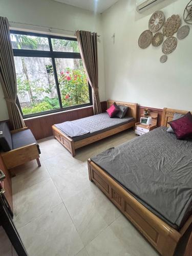 ein Schlafzimmer mit zwei Betten und einem Fenster in der Unterkunft Mellowmoo Homestay in Nguyễn Thôn