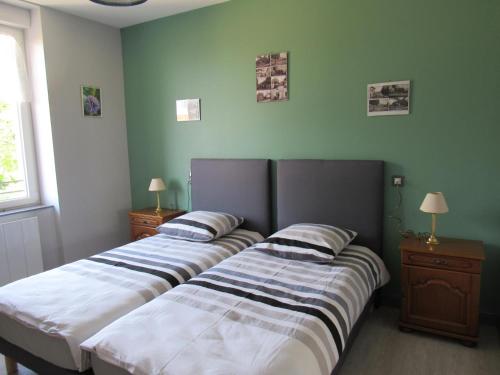 two beds in a room with green walls at Le gîte de la butte in Champagné-Saint-Hilaire