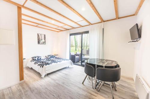 a bedroom with a bed and a glass table at Le gite de l'erable in Montamisé
