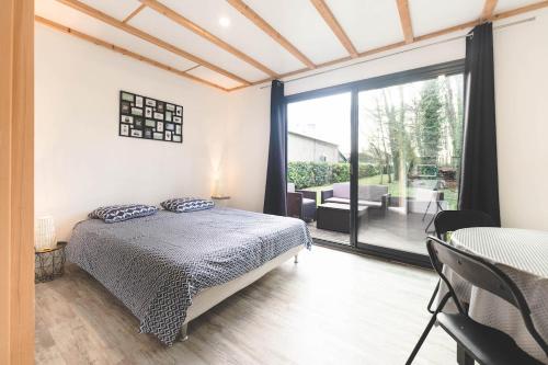 a bedroom with a bed and a large window at Le gite du prunus in Montamisé