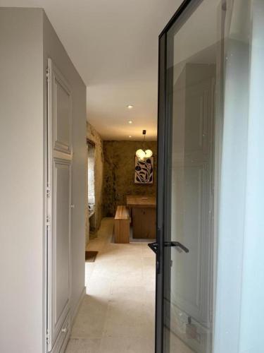 a hallway with a glass door leading into a room at Le troglo du château in Beaumont