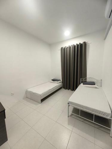 a room with two beds and a curtain at SWee Garden Homestay in Kota Tinggi