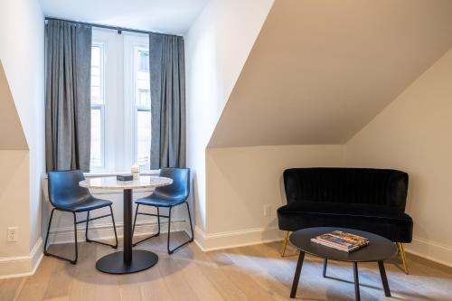 a living room with a table and chairs at Thena Hotel - Spacious Studio in Philadelphia