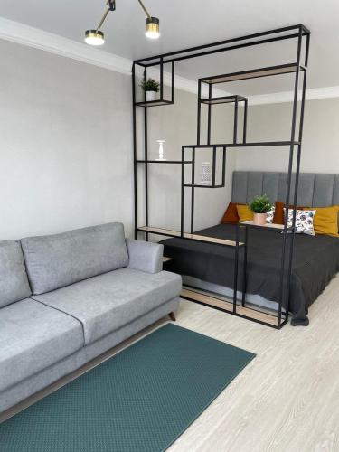 sala de estar con sofá y litera en Уютный апартамент, en Öskemen
