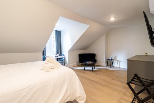 a bedroom with a white bed and a chair at Thena Hotel - Spacious Studio in Philadelphia
