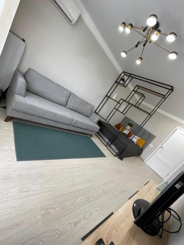 Una sala de estar con un sofá y una ventana de cristal. en Уютный апартамент, en Öskemen