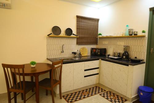 a kitchen with a sink and a table and chairs at Hotel Aeroview Near Chennai Airport in Chennai