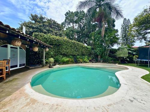 a swimming pool in the yard of a house at Casa Haru Alberca climatizada Jardín, asador y tombling, Capacidad 14 personas, 5 recámaras 5 baños 8 camas Estacionamiento para 4 autos Salida 5 pm in Cuernavaca