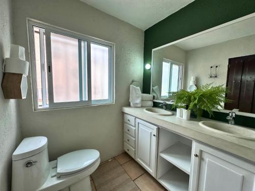 a bathroom with a toilet and a sink and a mirror at Casa Haru, Hermosa casa con alberca climatizada, jardín, asador y tombling, capacidad para 14 personas, 5 recámaras, 8 camas, 5 baños estacionamiento para 4 autos in Cuernavaca