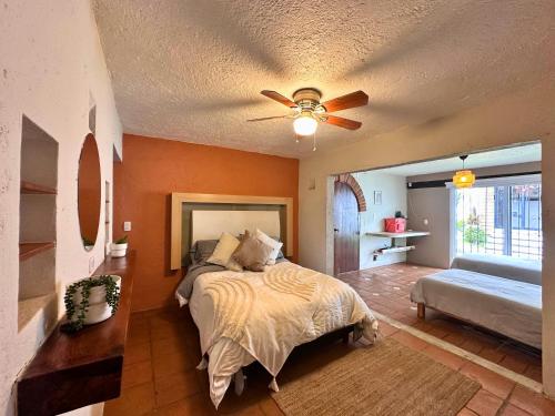 a bedroom with a bed and a ceiling fan at Casa Haru, Hermosa casa con alberca climatizada, jardín, asador y tombling, capacidad para 14 personas, 5 recámaras, 8 camas, 5 baños estacionamiento para 4 autos in Cuernavaca