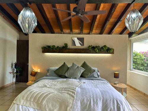 a bedroom with a bed with a ceiling fan at Casa Haru Alberca climatizada Jardín, asador y tombling, Capacidad 14 personas, 5 recámaras 5 baños 8 camas Estacionamiento para 4 autos Salida 5 pm in Cuernavaca