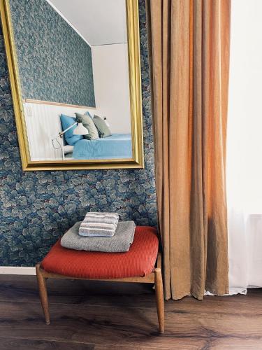 a chair with a red ottoman in front of a mirror at Ryds Gästgiveri in Ryd