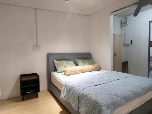 a bedroom with a large bed with a night stand at Halwa Homestay in Semporna