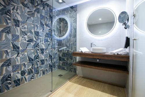 un baño con lavabo y espejo en Evenia Olympic Suites, en Lloret de Mar