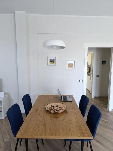 a wooden table with a pizza and a laptop on it at Cogoleto - Villetta Il Canneto in Cogoleto