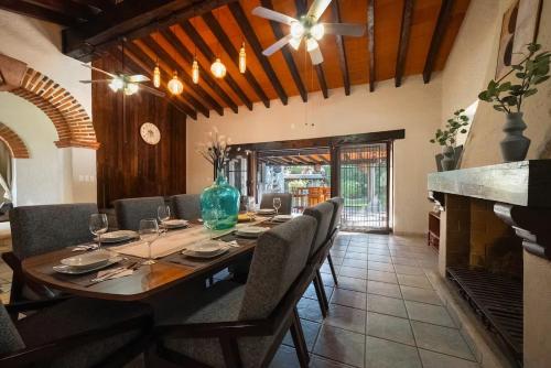 a dining room with a table with chairs and a fireplace at Casa Haru Alberca climatizada Jardín, asador y tombling, Capacidad 14 personas, 5 recámaras 5 baños 8 camas Estacionamiento para 4 autos Salida 5 pm in Cuernavaca