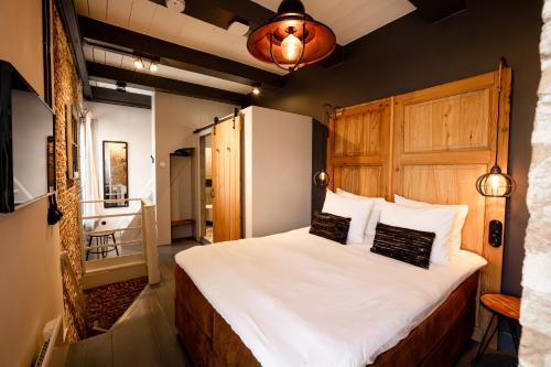 ミデルブルフにあるDe Koepoortの木製のヘッドボードが付いた大きなベッドのある寝室