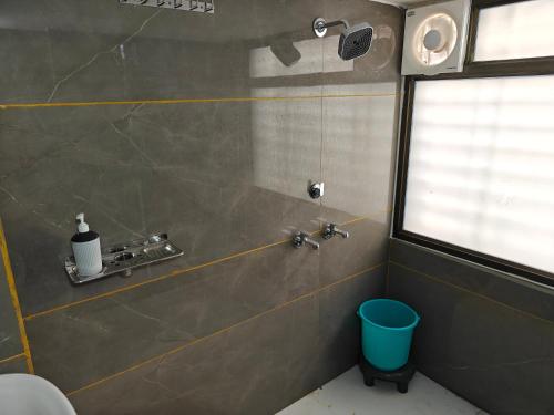 a bathroom with a shower with a sink and a window at HOTEL KRISHNAM By TruStay in Satna