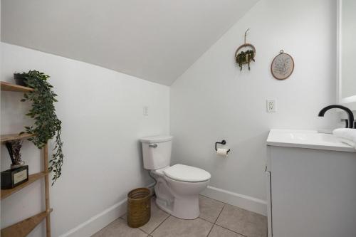 a white bathroom with a toilet and a sink at Heights Haus in Peoria Heights