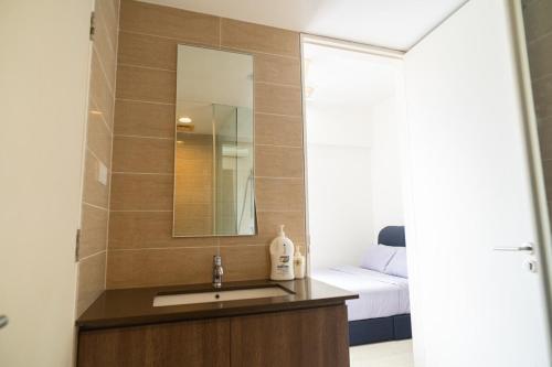un baño con lavabo y espejo en Cozy Seaview Escape 2BR 6pax bythesea bathroom, en Pulau Pinang