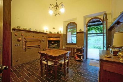 a kitchen with a wooden table and a fireplace at Historic Villa In The Tuscan Woods And Hills in Casteldelci