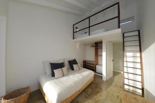 a bedroom with a bed with white sheets and black pillows at Quinta do Alvisquer in Alvisquer