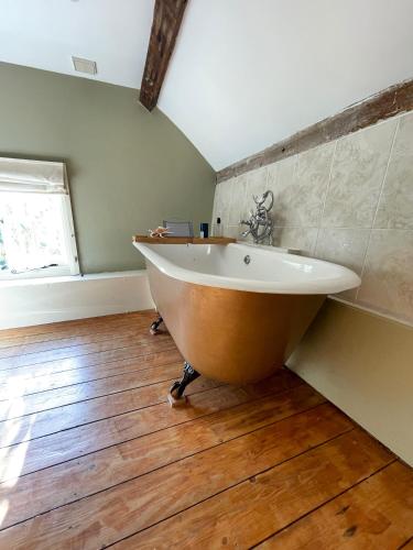 a bath tub in a room with a wooden floor at Bartley Mill in Wadhurst