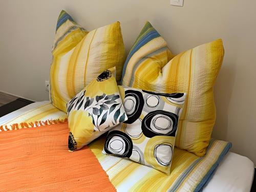 une pile d'oreillers sur un lit dans une chambre dans l'établissement Paradis de Provence Gite Jaune, à Le Pin