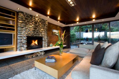 a living room with a large stone fireplace at Forty Two by Amazing Accom in Queenstown