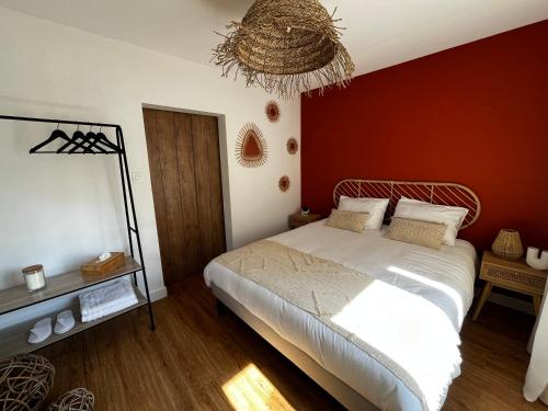a bedroom with a bed and a red wall at L'instant SPA in Maulde