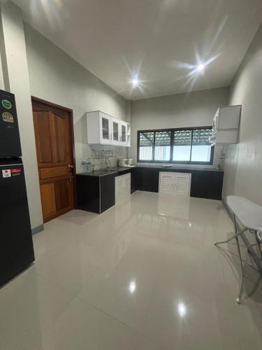 a large kitchen with white tile flooring and a large room at Ban Mae Ku 