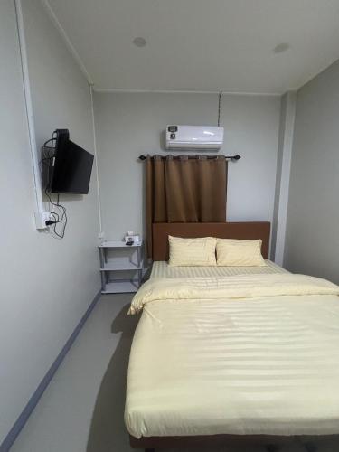 a small room with a bed and a television at Ban Mae Ku 