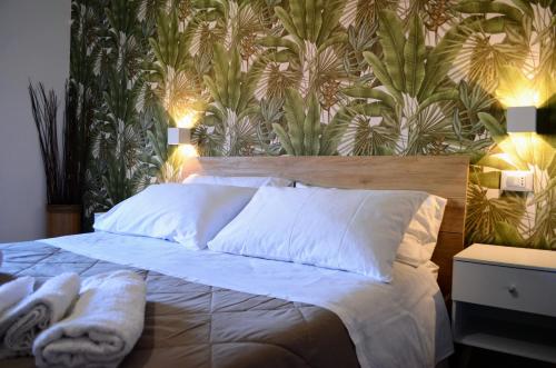 a bedroom with a large bed with a tropical wallpaper at Terra D'Amuri in Belpasso