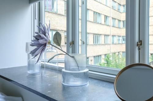 コペンハーゲンにあるSpacious 3-Bedroom Apartment in Embassy Districtの窓辺に置かれた花瓶に花が挿してある