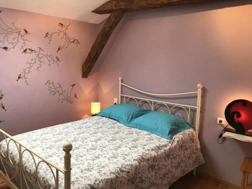 a bedroom with a white bed with blue pillows at Le moulin de chaume in Champagné-Saint-Hilaire