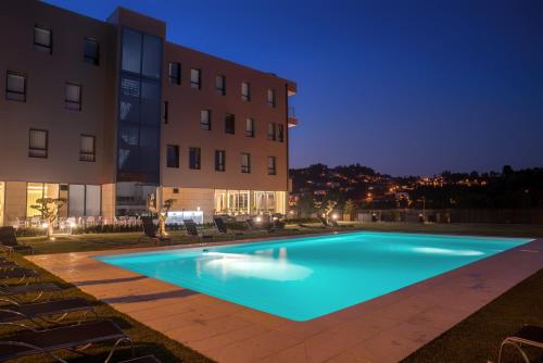 una piscina frente a un edificio por la noche en Flag Hotel Celorico Palace, en Celorico de Basto