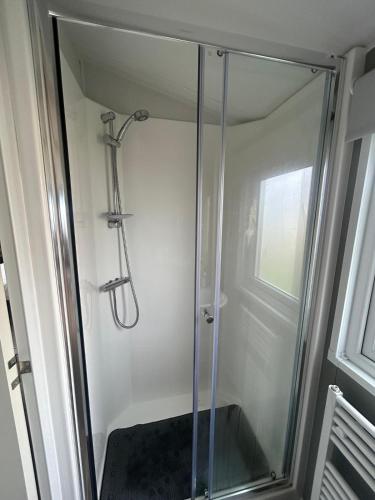 a shower with a glass door in a bathroom at Sea View by the beach at Crimdon Dene Holiday Park in Hartlepool